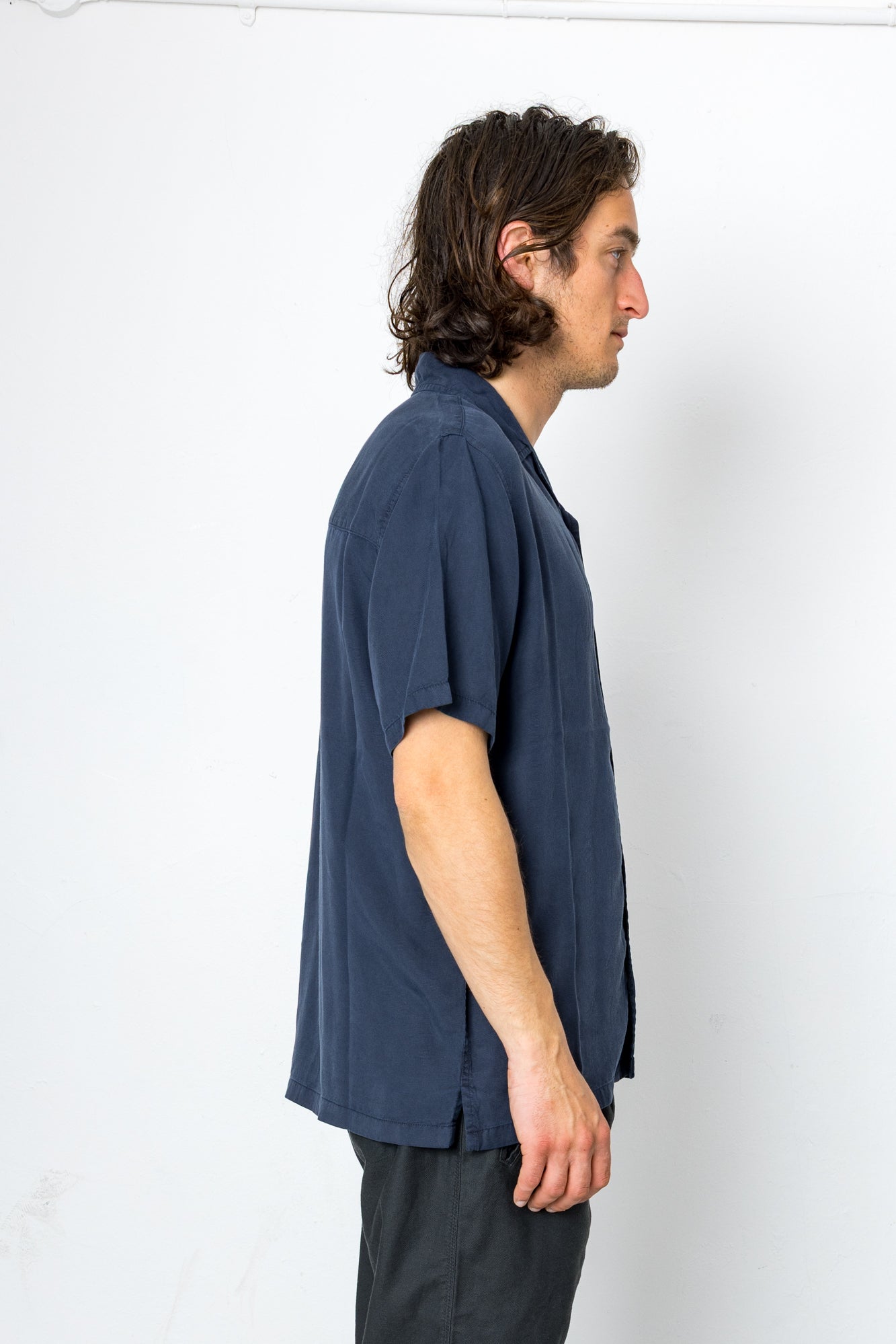Man wearing a navy blue shirt against a white background