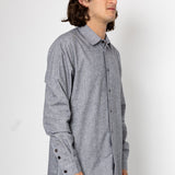 Man wearing a gray checkered shirt against a white background