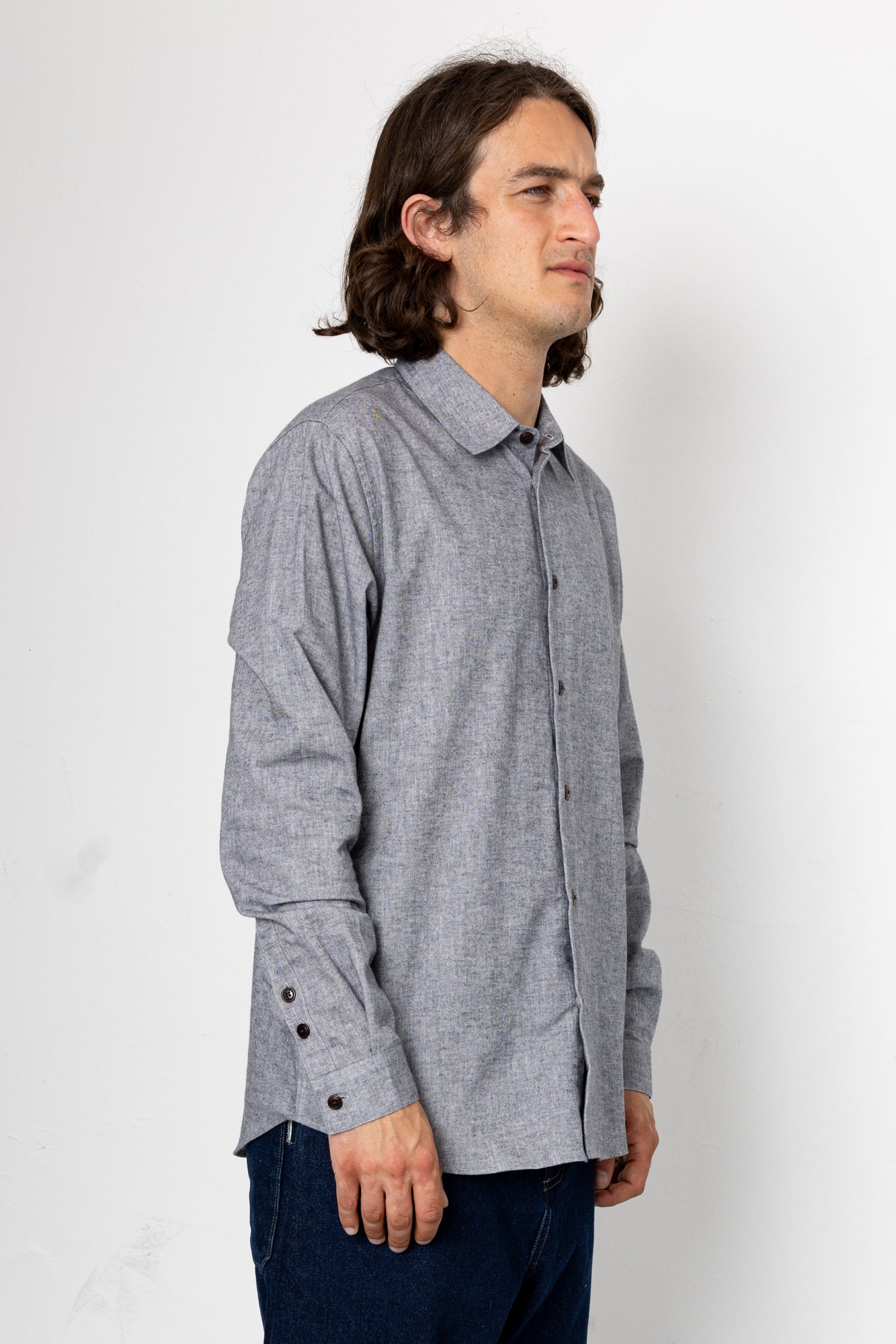 Man wearing a gray checkered shirt against a white background