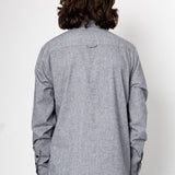 Person wearing a gray long-sleeve shirt against a white background