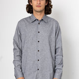 Man wearing a gray button-up shirt against a white background