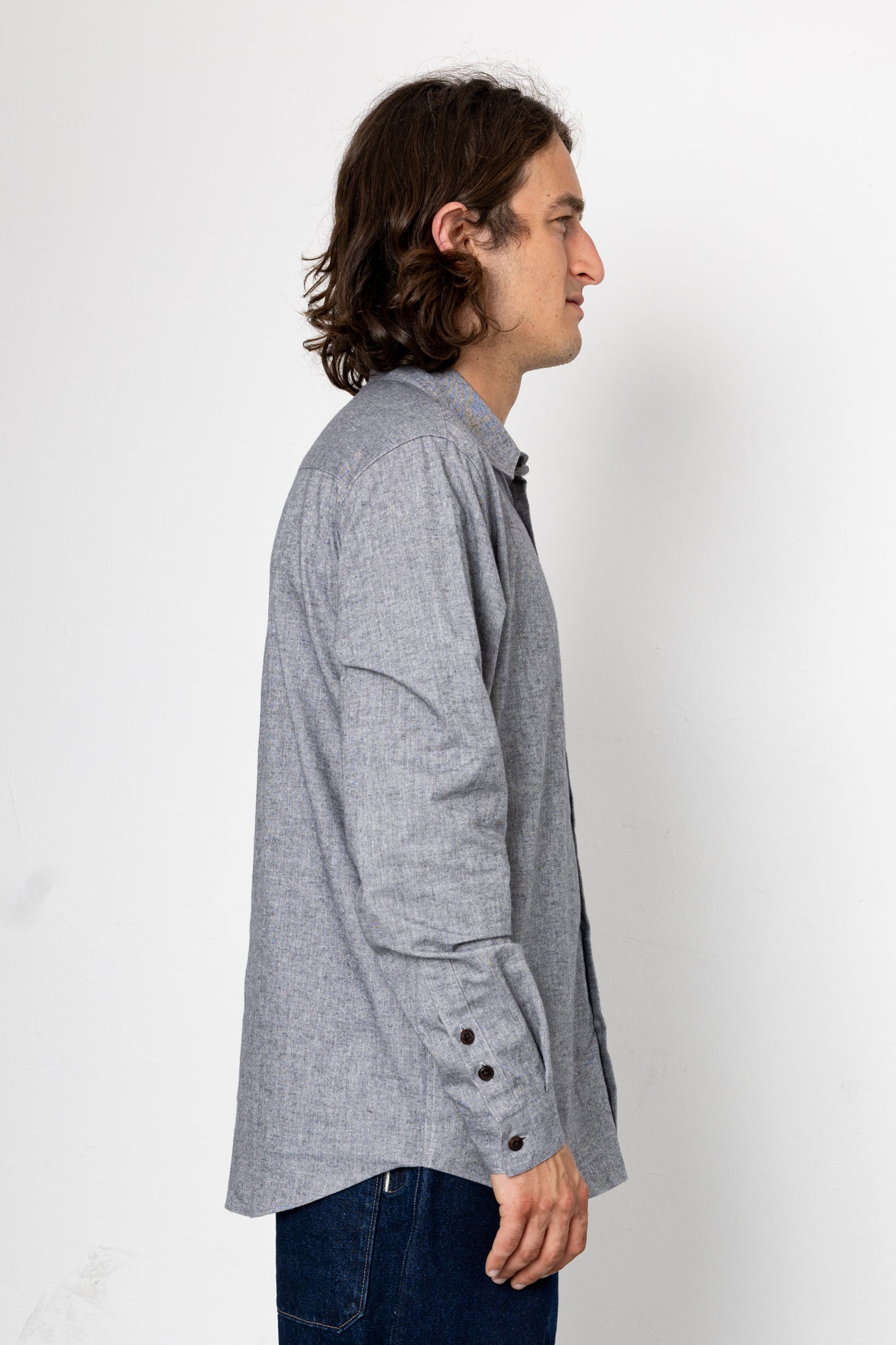 Man wearing a gray checkered shirt against a white background