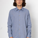 Man wearing a blue patterned shirt against a white background