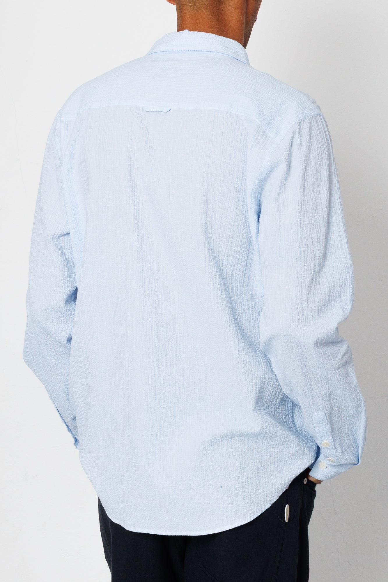 Light blue striped shirt worn by a person on a plain background