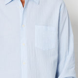 Light blue striped shirt worn by a person on a plain background