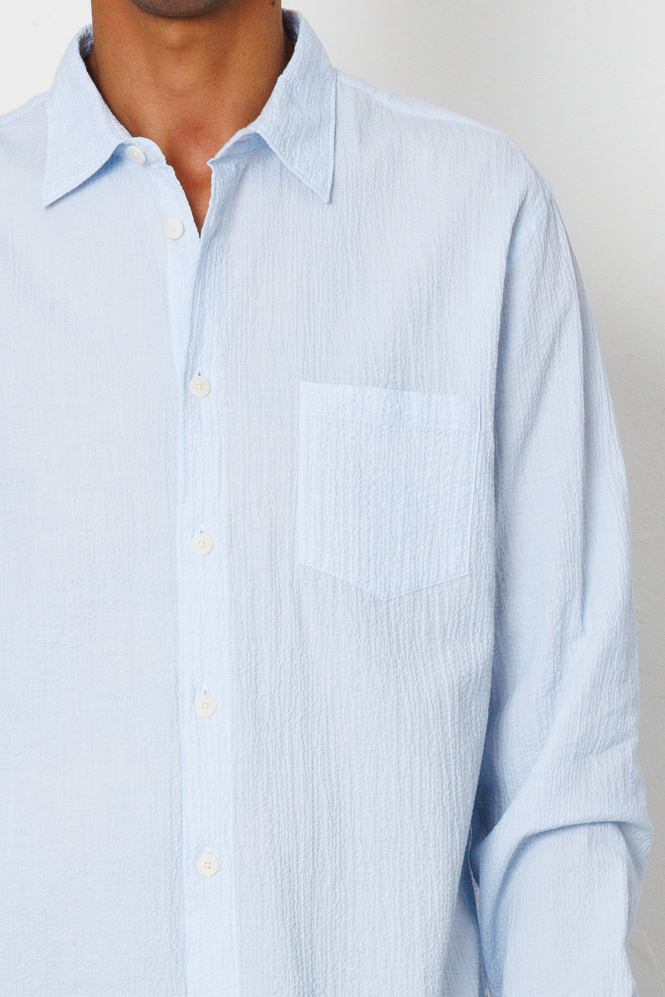 Light blue striped shirt worn by a person on a plain background