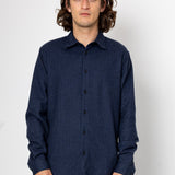Man wearing a dark blue textured shirt against a white background
