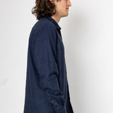 Man wearing a dark blue textured shirt against a white background