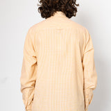 Person wearing a beige shirt from behind on a white background