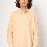 Man wearing a light pink shirt against a white background