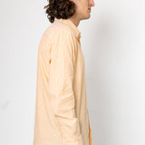 Man wearing a light beige shirt against a white background