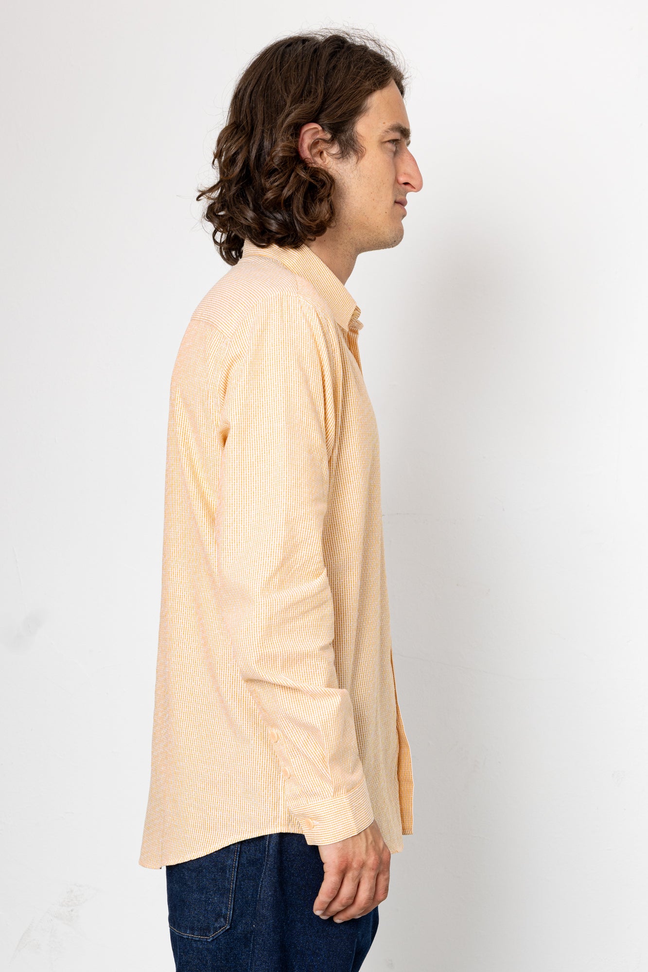 Man wearing a light beige shirt against a white background