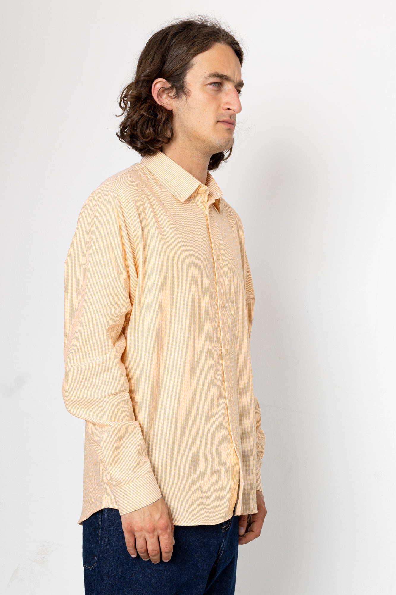 Man wearing a beige shirt against a white background