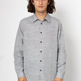 Man wearing a back and white shirt against a light grey background