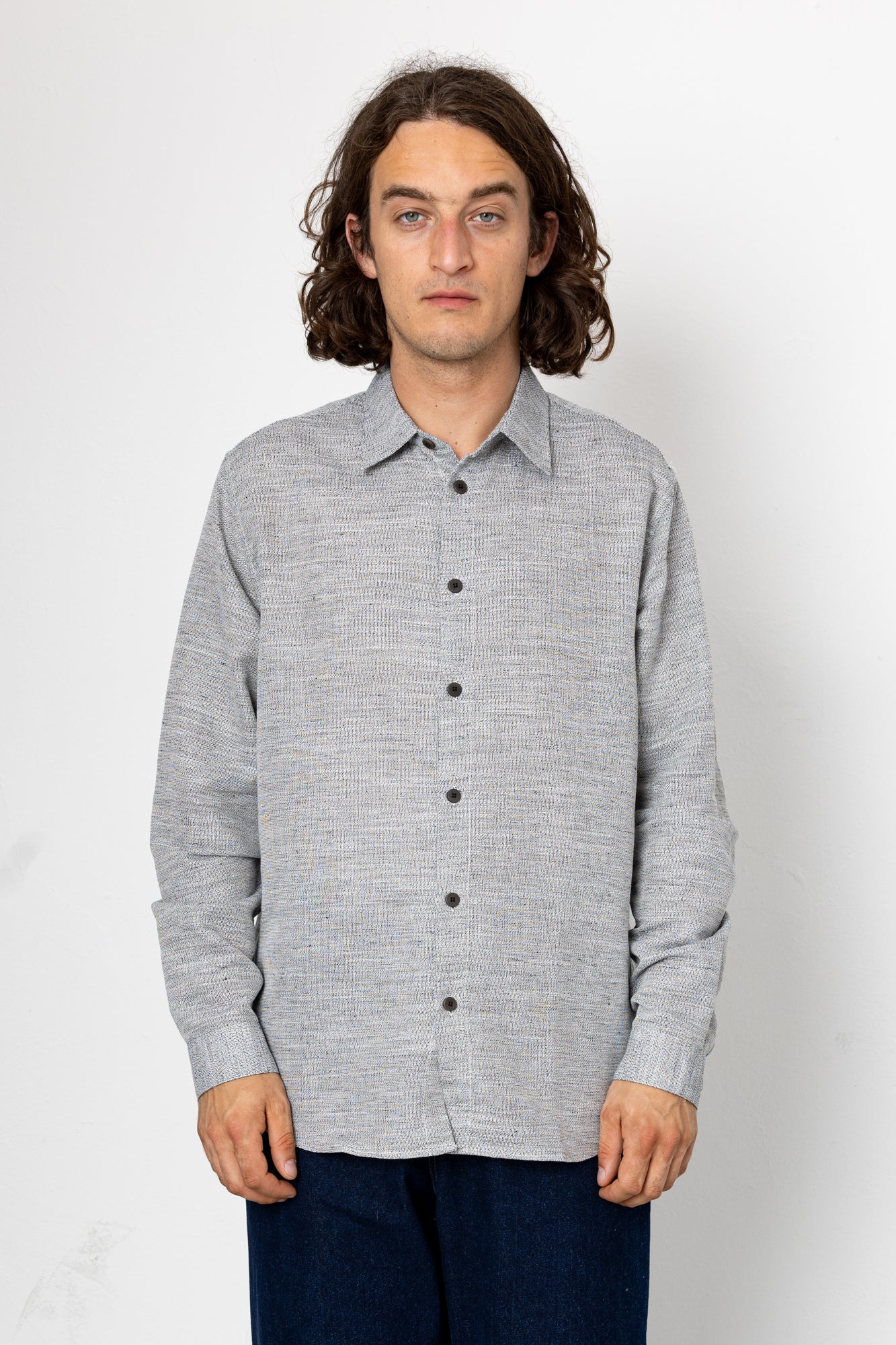 Man wearing a back and white shirt against a light grey background