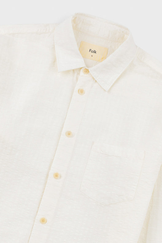 White shirt with yellow buttons on a white background