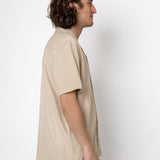 Man wearing a beige shirt against a white background