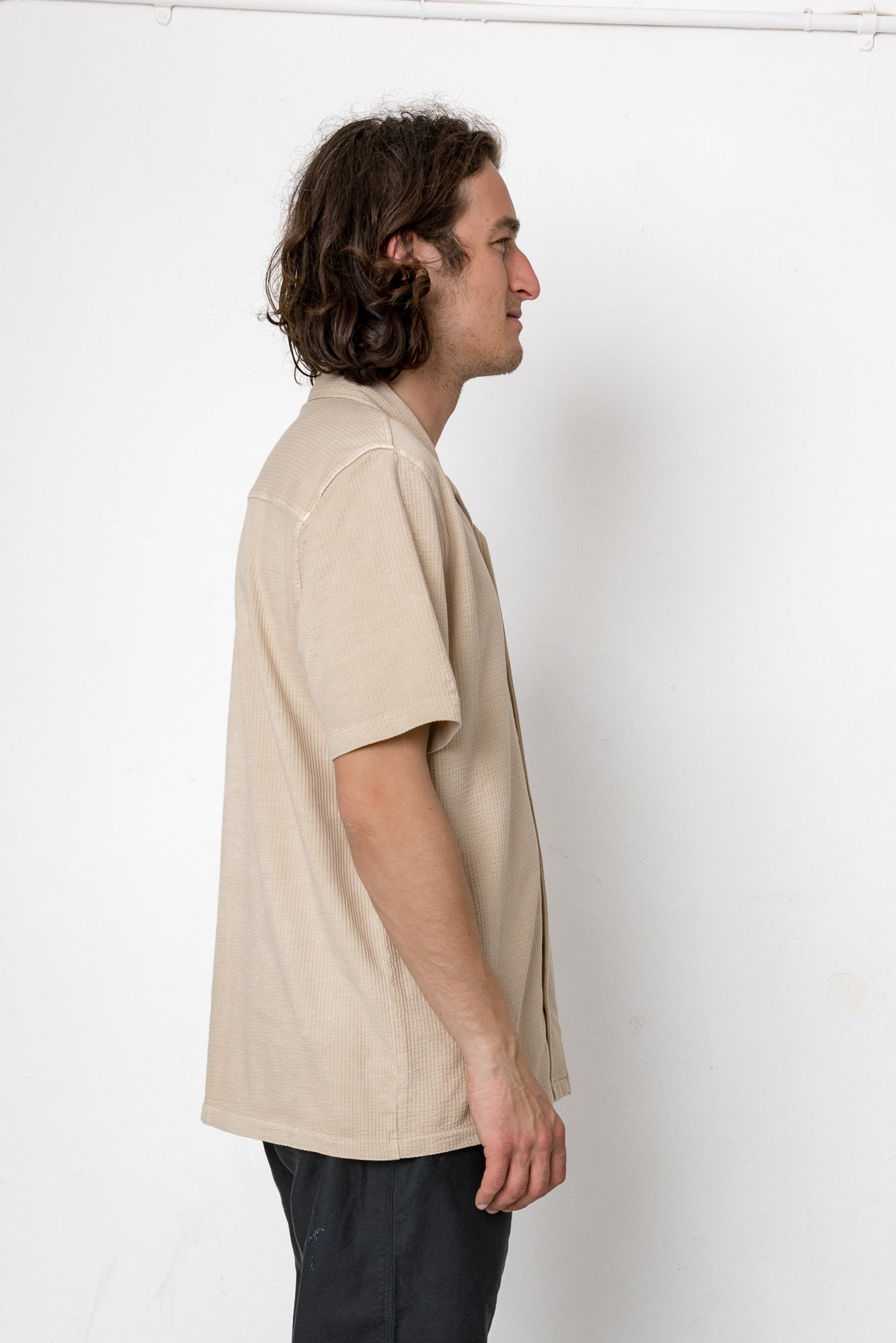 Man wearing a beige shirt against a white background