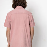 Person wearing a pink shirt against a white background