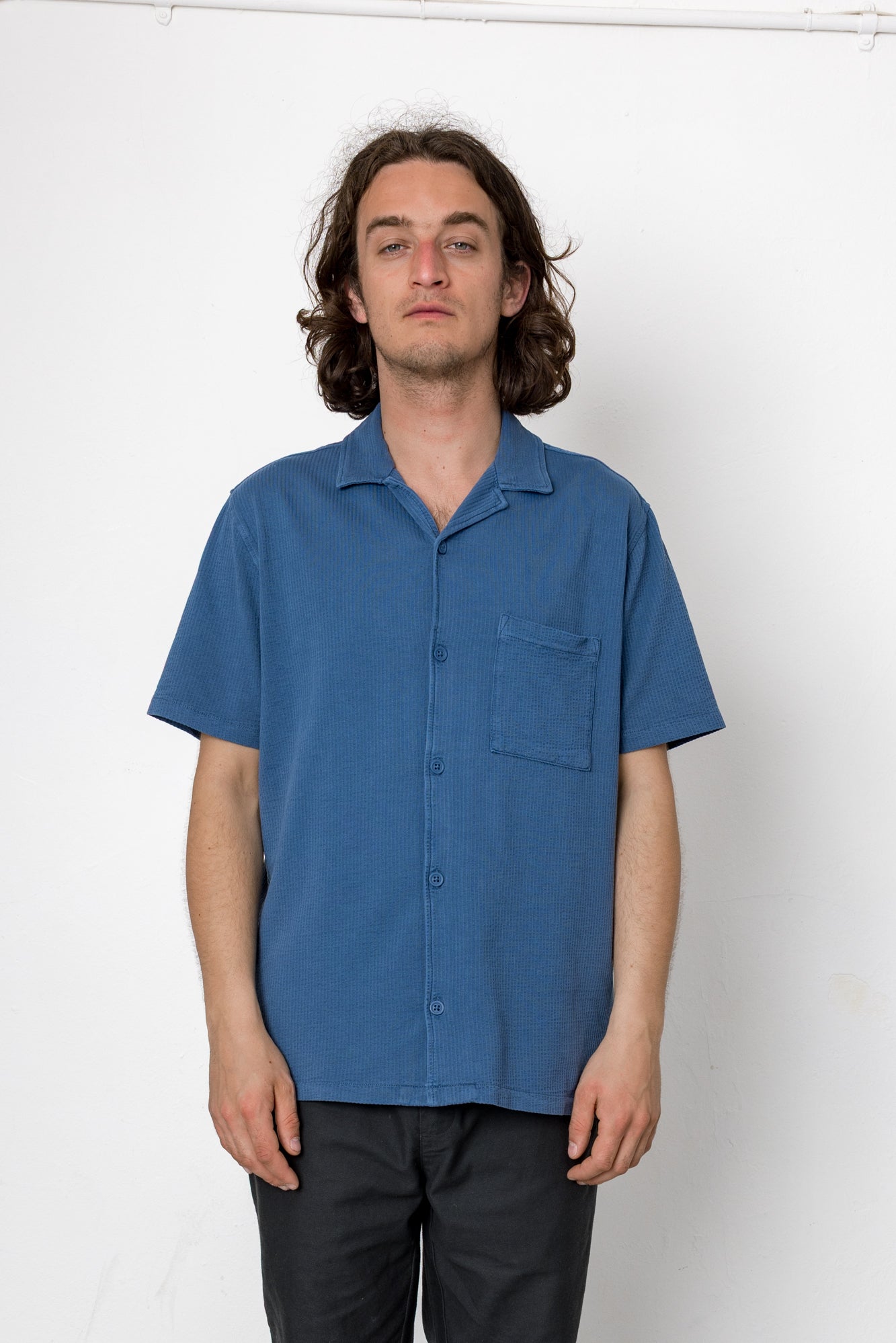Man wearing a blue shirt against a white background