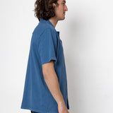 Man wearing a blue shirt against a white background