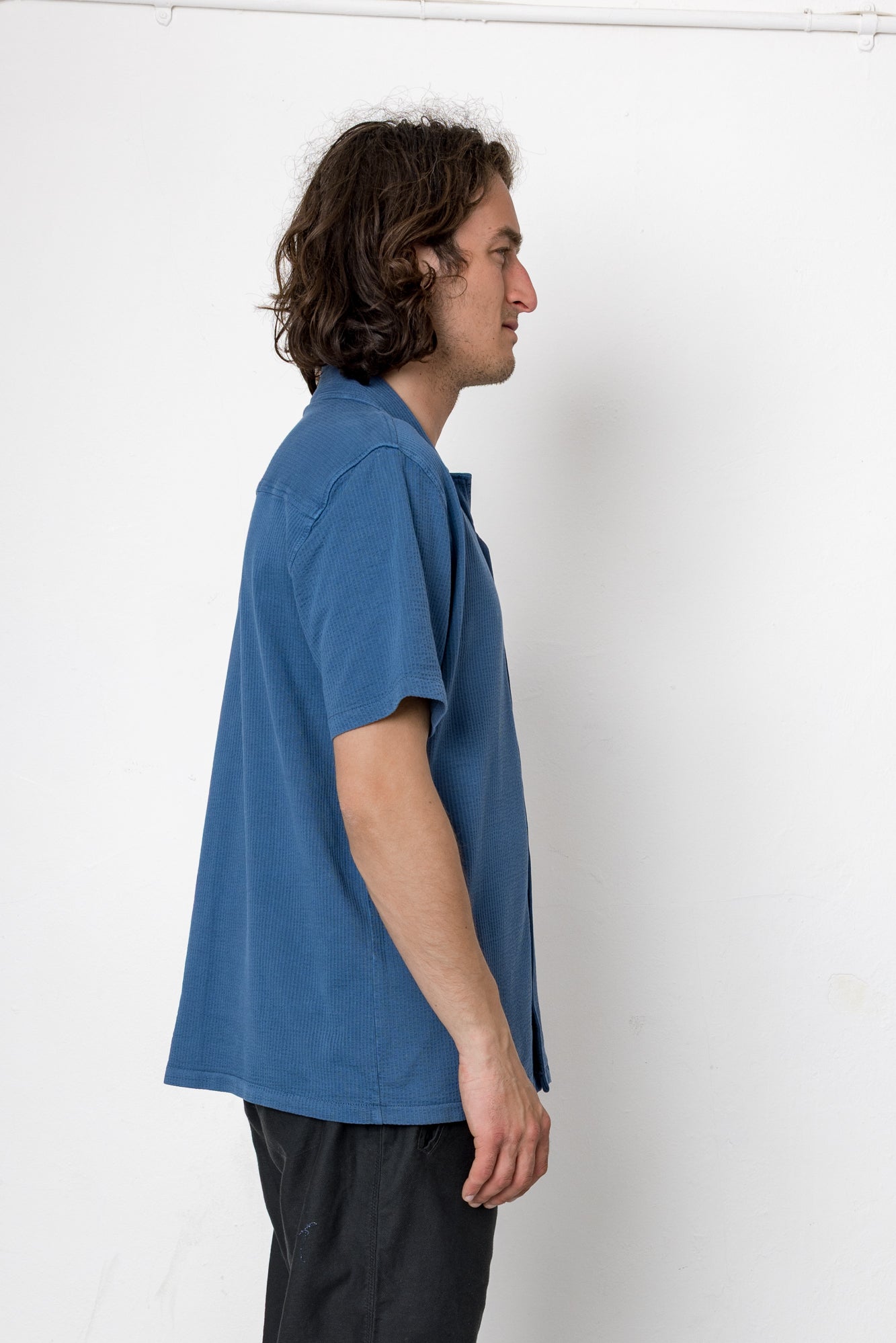 Man wearing a blue shirt against a white background