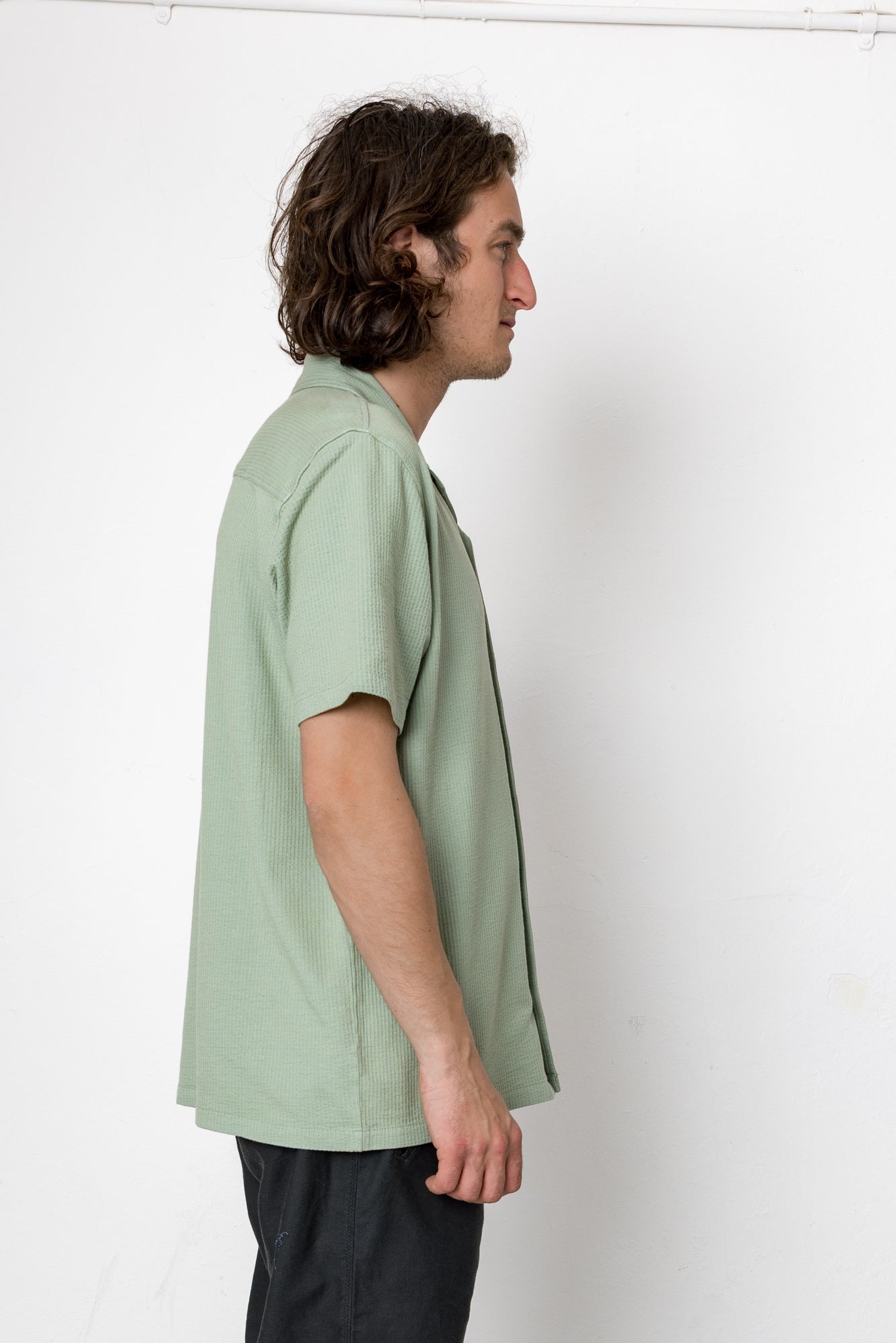 Man wearing a light green shirt against a white background