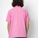 Person wearing a pink shirt from behind on a white background