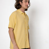 Person wearing a yellow shirt against a white background