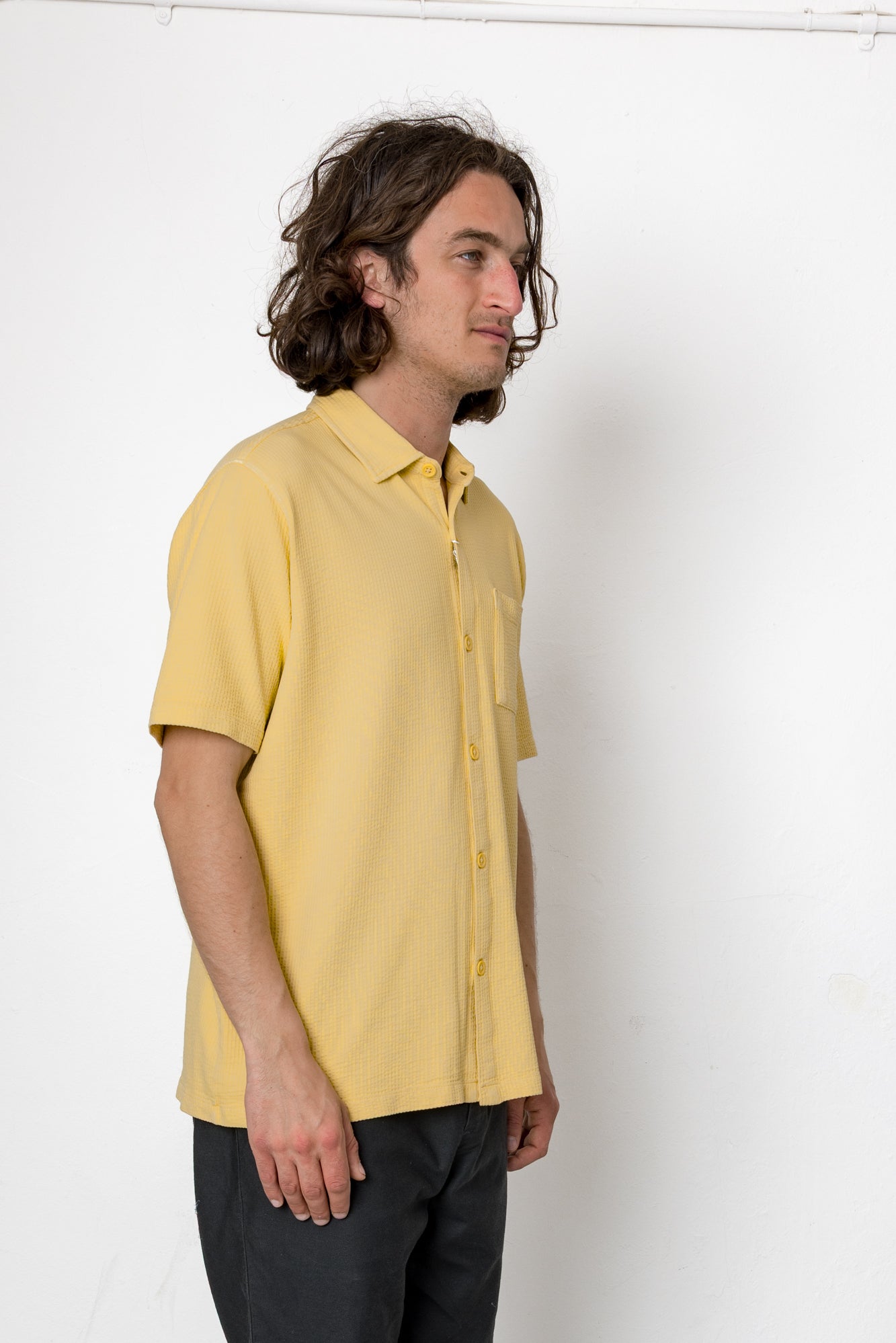 Person wearing a yellow shirt against a white background