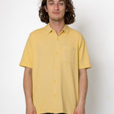 Man wearing a yellow shirt against a white background
