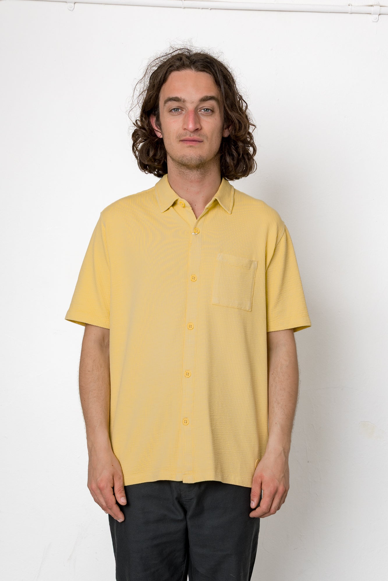 Man wearing a yellow shirt against a white background