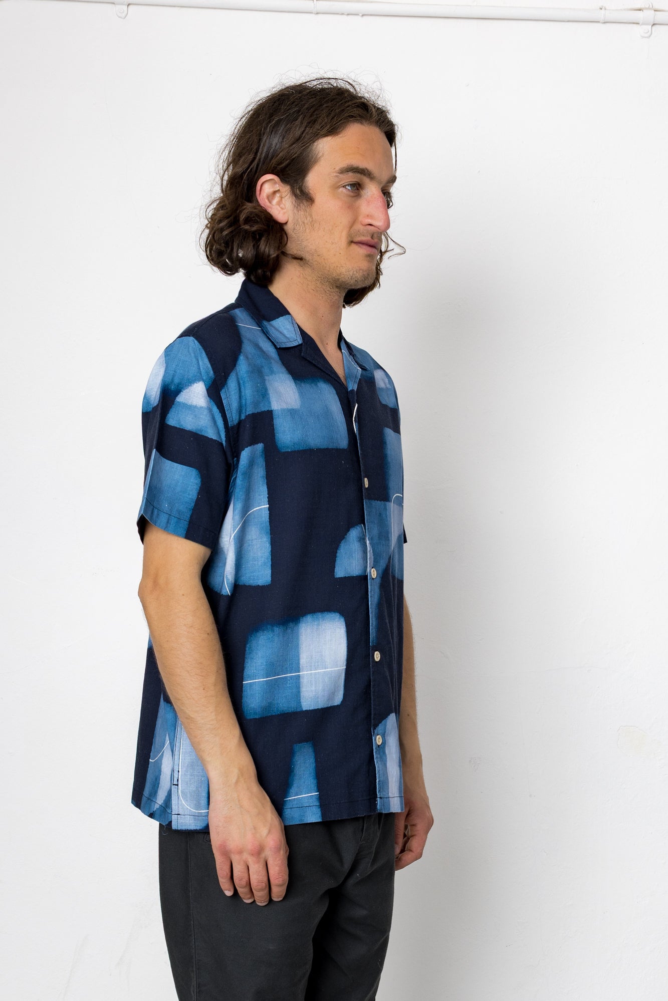 Man wearing a blue patterned shirt against a white background