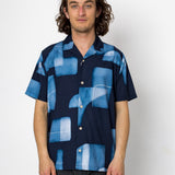 Man wearing a blue patterned shirt against a white background