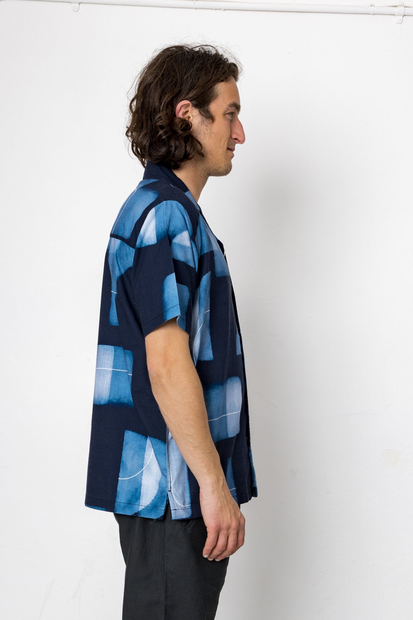 Man wearing a blue patterned shirt against a white background