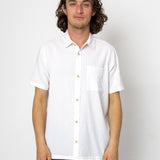 Man wearing a white short-sleeve shirt against a plain background