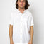 Man wearing a white short-sleeve shirt against a plain background