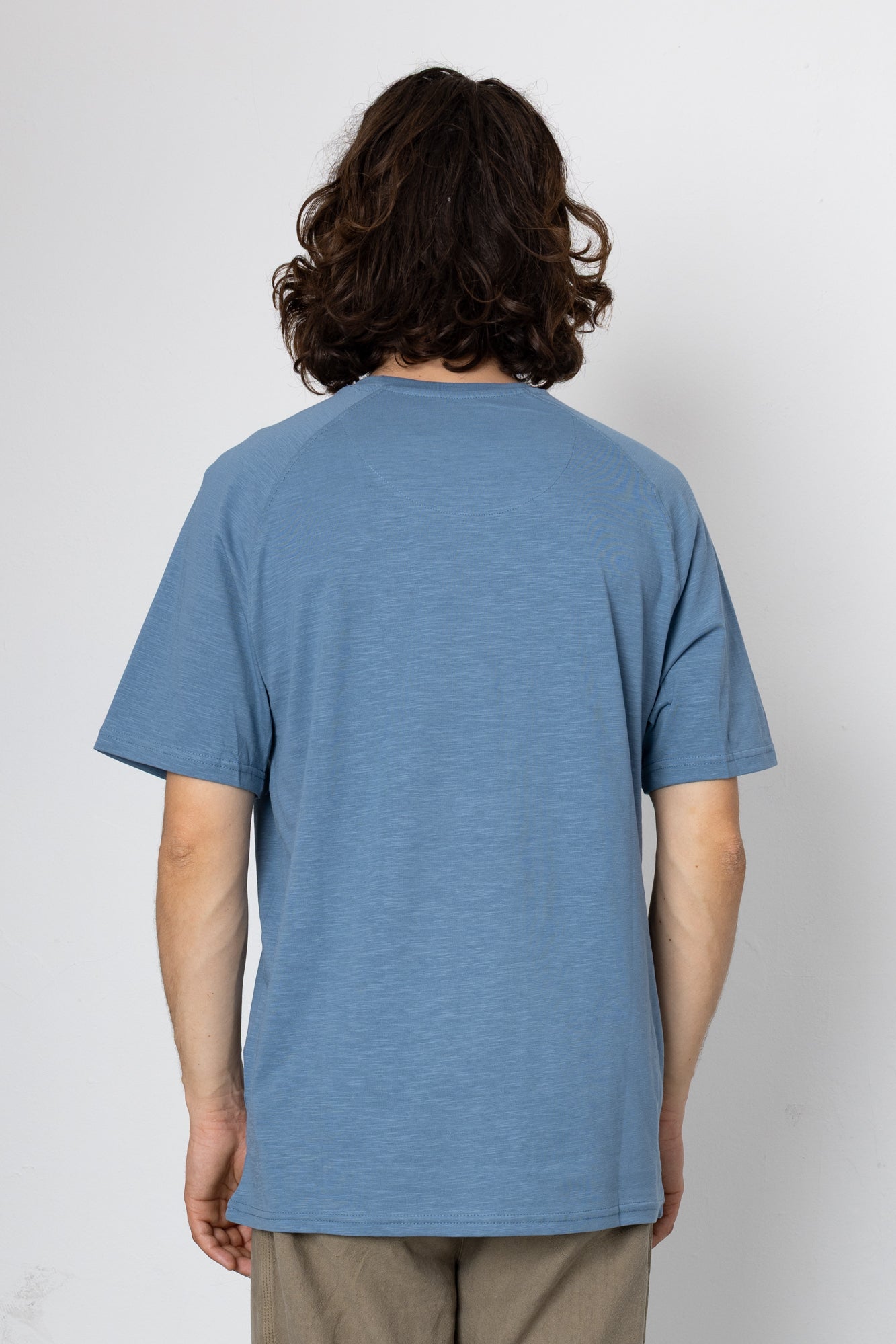 Person wearing a blue t-shirt against a white background