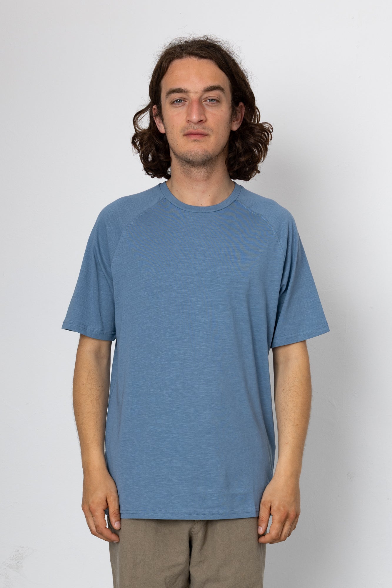 Person wearing a blue t-shirt against a white background