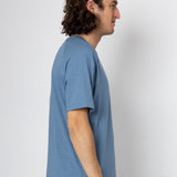 Man wearing a blue t-shirt against a white background