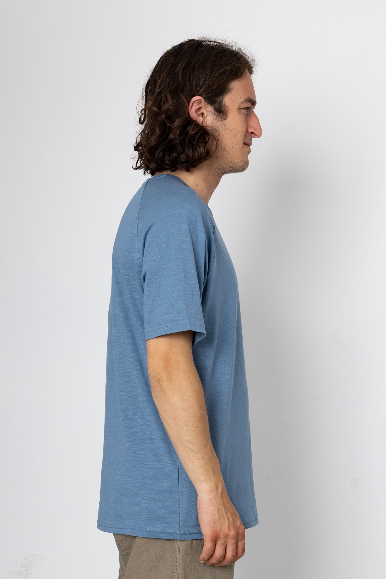 Man wearing a blue t-shirt against a white background