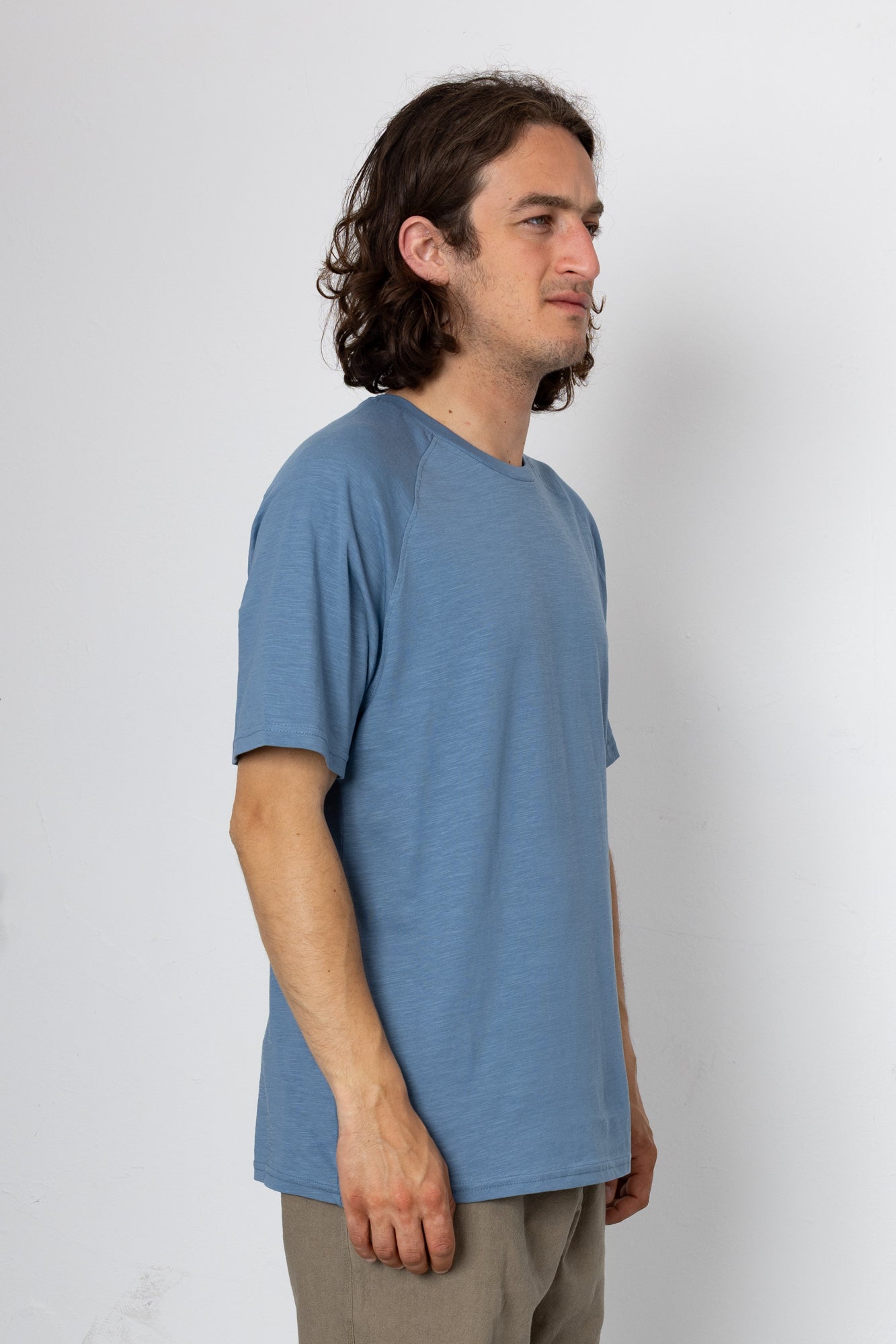Man wearing a blue t-shirt against a white background