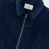 Close-up of a navy blue corduroy zip-up jacket with a collar and a white neck label reading 'Folk'.
