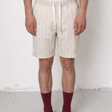 Person wearing beige shorts and maroon socks against a white background