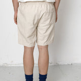 Person wearing beige shorts and navy socks on a white background