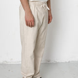 Person wearing beige pants and black shoes against a white background