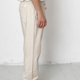Person wearing beige pants and black shoes on a white background