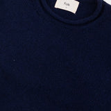 Navy blue sweater with a visible brand label on a white background