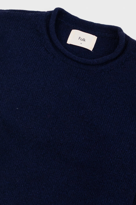 Navy blue sweater with a visible brand label on a white background
