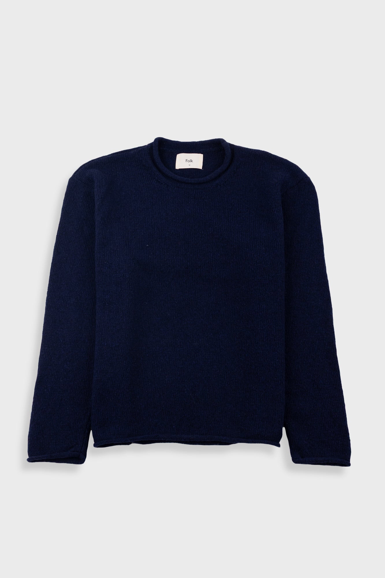 Navy blue sweater with a visible brand label on a white background